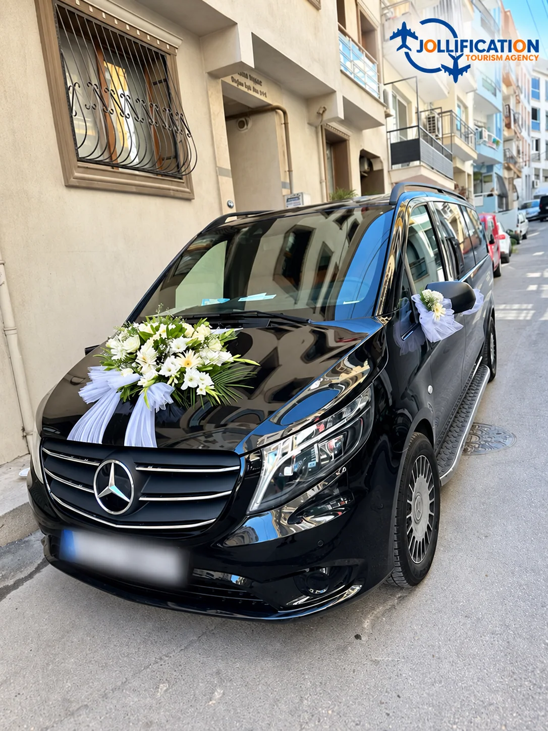 Beyaz çiçeklerle süslenmiş siyah Mercedes gelin aracı